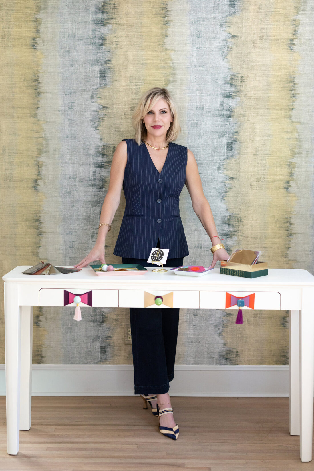 Summer Savin at her white console with STANDOUT hardware, against her ikat art wall